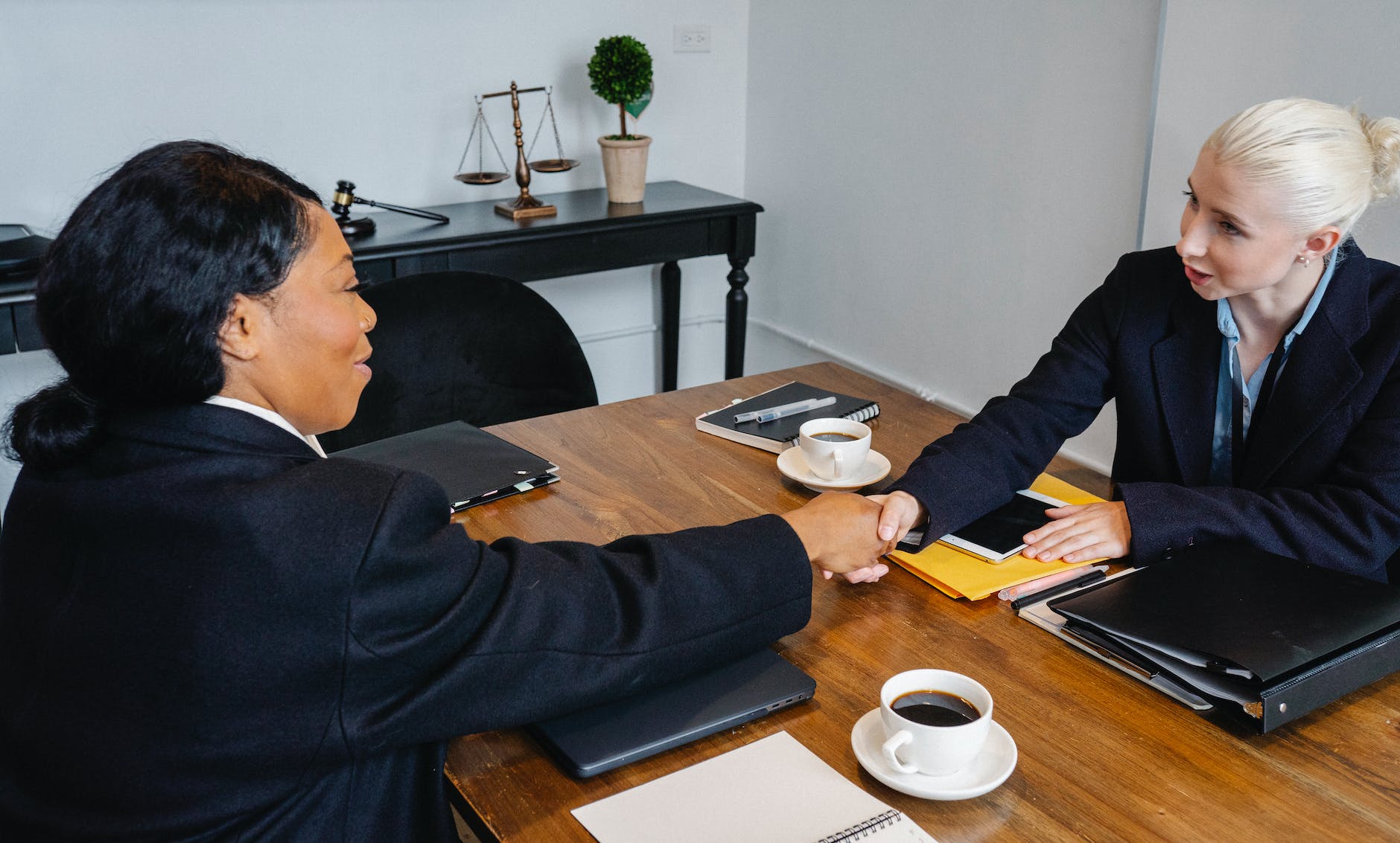 cheerful businesswomen shaking hands during meeting